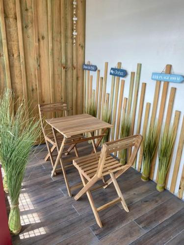 einen Holztisch und Stühle auf einer Holzterrasse in der Unterkunft T2 Arcachon (Aiguillon) accès immédiat à la plage in Arcachon
