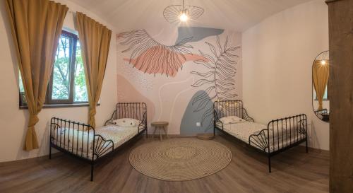 a room with two beds and a wall with a bird mural at Linden House - A lovely apartment in central Varna in Varna City