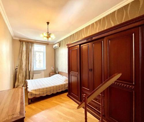 a bedroom with a bed and a large wooden cabinet at Cascade Residence in Yerevan