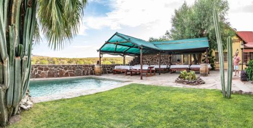 einen Pool mit blauem Baldachin und eine Terrasse in der Unterkunft Maltahöhe Hotel in Maltahöhe