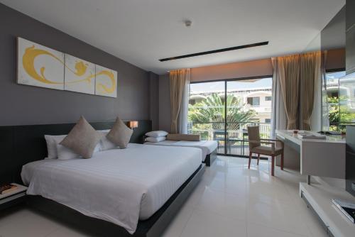 a hotel room with two beds and a balcony at Patong Beachfront Studio 2 Mins Walk 2 Patong Beach in Patong Beach