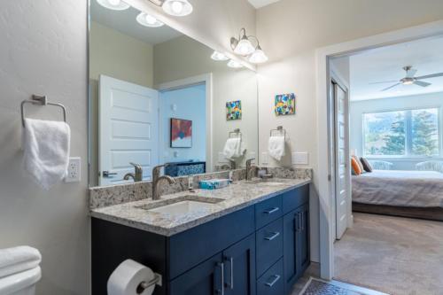 a bathroom with a double sink and a bedroom at Sail Lofts by Summit County Mountain Retreats in Dillon