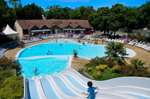 - une piscine dans un complexe avec des personnes dans l'eau dans l'établissement Agréable Mobilhome 6 - 8 places, à Saint-Brévin-les-Pins