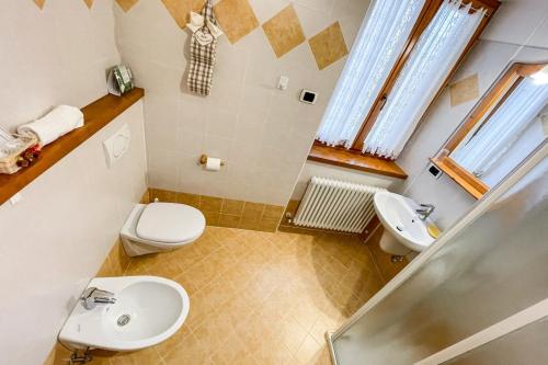a small bathroom with a toilet and a sink at Room & Breakfast Cà mea Dina in Ledro