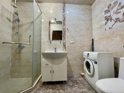 a bathroom with a sink and a washing machine at Cascade Residence in Yerevan