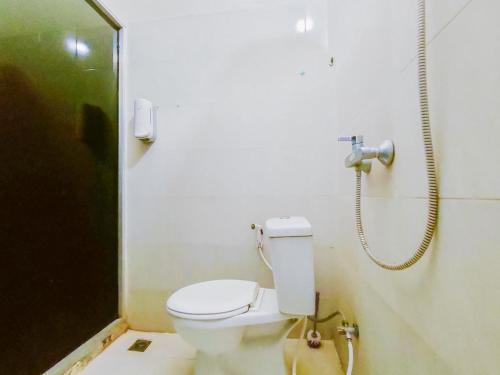 een badkamer met een toilet en een telefoon aan de muur bij RedDoorz Syariah at Jemursari Surabaya in Surabaya