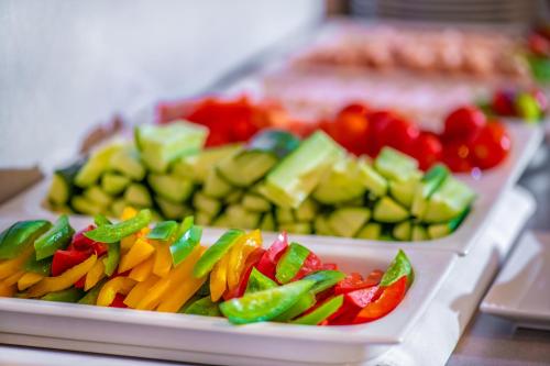 two trays filled with different types of vegetables on a table at Charm Hotel Budapest - formerly Boutique Hotel Budapest in Budapest