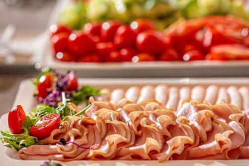 a plate of food on a table with tomatoes at Charm Hotel Budapest - formerly Boutique Hotel Budapest in Budapest