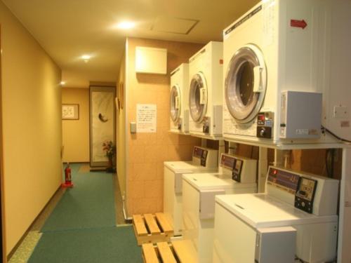 a laundry room with washing machines and a hallway at KOUBOUNOYU HONTEN in Shizuoka