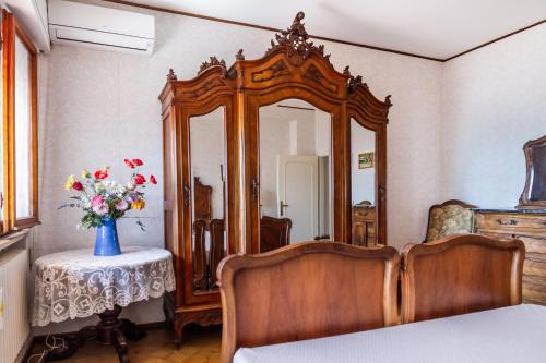 ピオンビーノにあるLa Casa sul Golfoのベッドルーム(鏡、花瓶付きテーブル付)