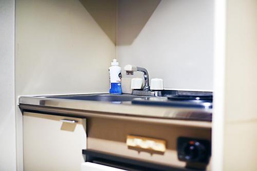 a kitchen sink with a bottle of soap on it at Asakusa nibankan in Tokyo