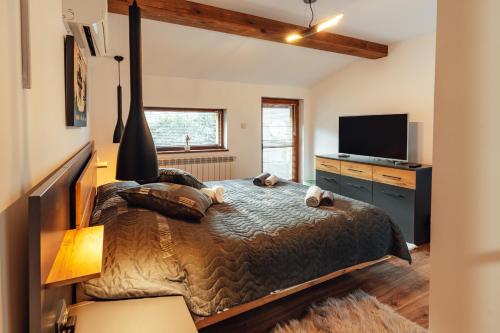 a bedroom with a bed and a flat screen tv at Guest house Anna-Maria in Velingrad