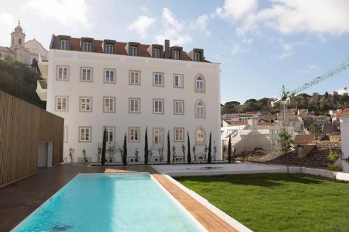 ein großes weißes Gebäude mit einem Pool davor in der Unterkunft FLH Mouraria Art Apartment with Pool in Lissabon