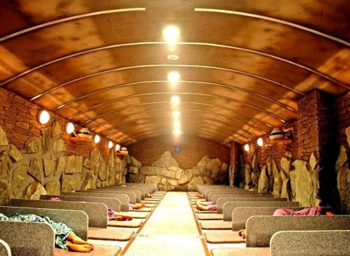 a long tunnel with chairs and a stone wall at KOUBOUNOYU NAGAOKA in Shizuoka