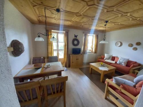 una sala de estar con una mesa y un sofá en Landhaus Friedl, en Riedlhütte