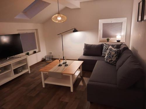 ein Wohnzimmer mit einem Sofa und einem Couchtisch in der Unterkunft Lütje Huus in Upgant-Schott