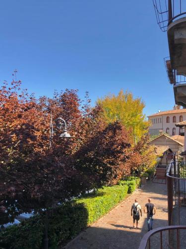 two people walking down a path in a park at Casa Clementi in Barolo