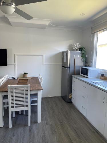 a kitchen with a table and a refrigerator at Busselton Jetty Chalets in Busselton