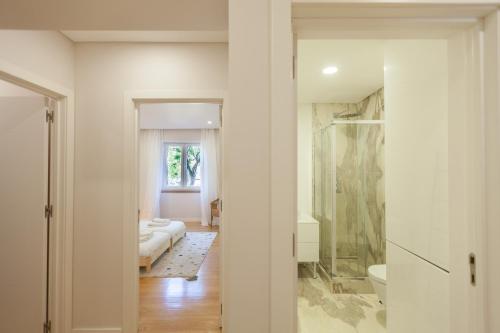 Cette chambre comprend un lit et une salle de bains pourvue d'une douche. dans l'établissement FLH Gulbenkian Apartment with Balcony, à Lisbonne