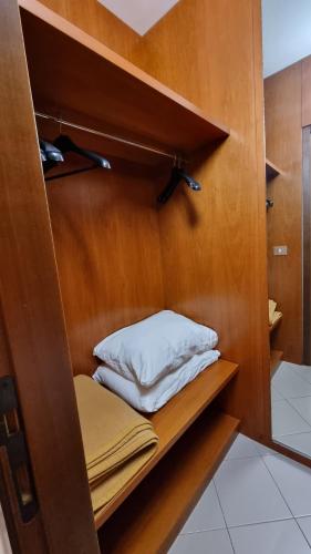 a room with a closet with a shelf and a pillow at Appartamento Punta Ala in Punta Ala