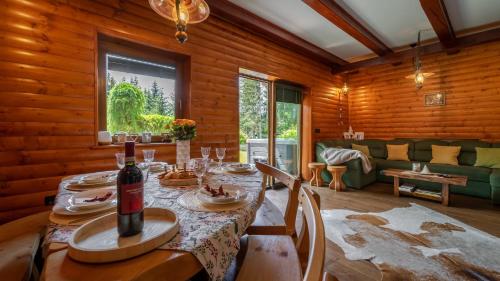 uma sala de jantar com uma mesa e uma garrafa de vinho em Gorska Vila em Mrkopalj