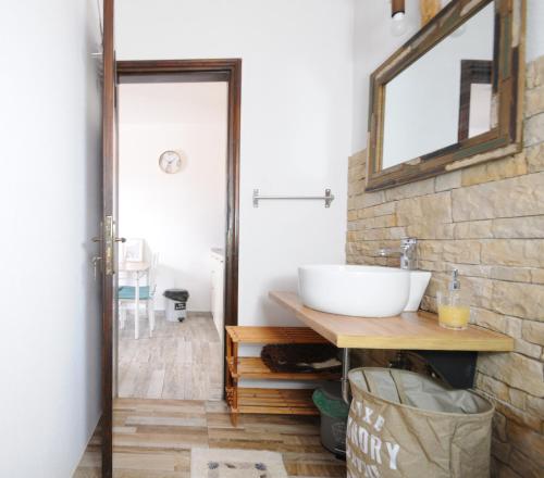 a bathroom with a sink and a mirror on a brick wall at Aris House - Cretan Hospitality in Agios Nikolaos