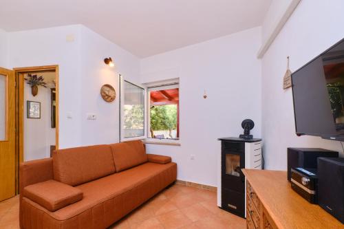 a living room with a couch and a flat screen tv at Apartments Antares in Mali Lošinj