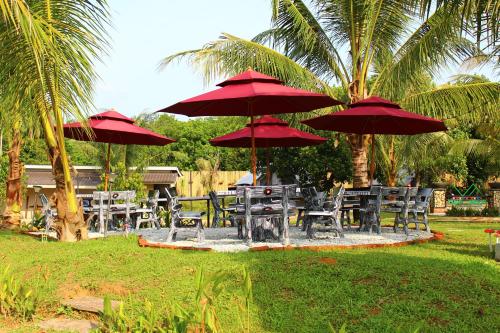 a group of tables and chairs with red umbrellas at Fraser Valley Kuala Kubu Bharu in Kuala Kubu Baharu