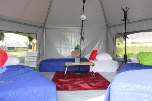 Zelt mit 2 Betten und einem Tisch in der Unterkunft Inap Dusun Fraser Valley Kuala Kubu Bharu in Kuala Kubu Baharu