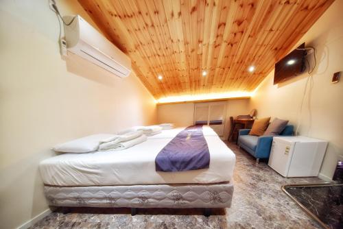 a bedroom with a bed and a couch in a room at The Road Hotel in Seoul