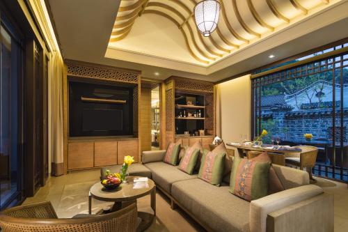 a living room with a couch and a television at Banyan Tree Yangshuo in Yangshuo