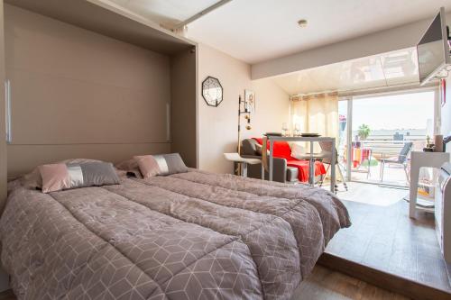 um quarto com uma cama grande e uma varanda em Cocooning em Cap d'Agde