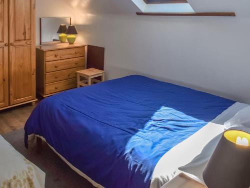 20 Blackbird Cottage-uk38935 في برثكورنو: غرفة نوم بسرير ازرق وبيض وخزانة