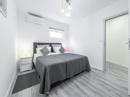 a white bedroom with a bed and a window at Family Holiday Home Nest in Mlini