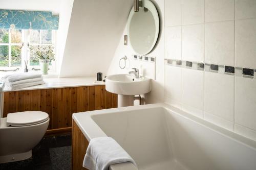 a white bath tub sitting next to a white toilet at Brace of Pheasants in Alton Pancras