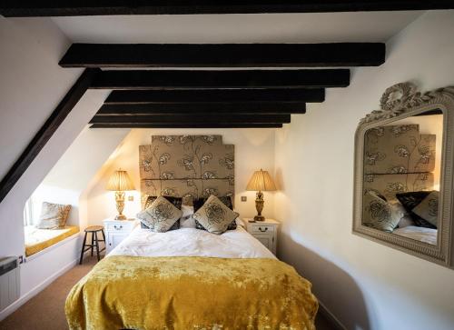 1 dormitorio con 1 cama con colcha amarilla en Brace of Pheasants, en Alton Pancras