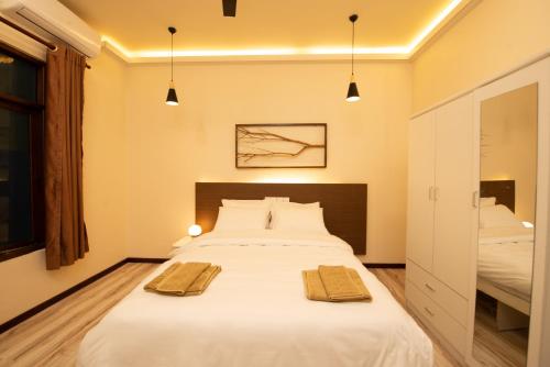 sypialnia z dużym łóżkiem z dwoma ręcznikami w obiekcie The Bilimbi Guesthouse & Inn w mieście Huraa