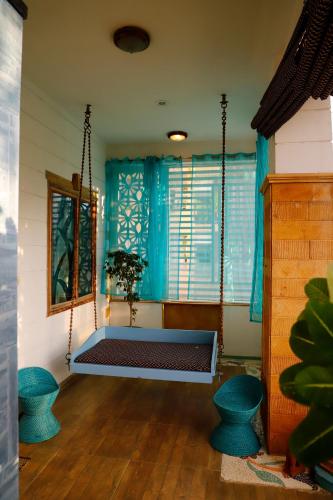 a porch swing in a room with blue curtains at Aura Homestay Royal Villa in Jaipur