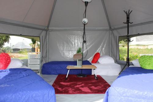 a tent with two beds and a table in it at Inap Dusun Fraser Valley Kuala Kubu Bharu in Kuala Kubu Baharu