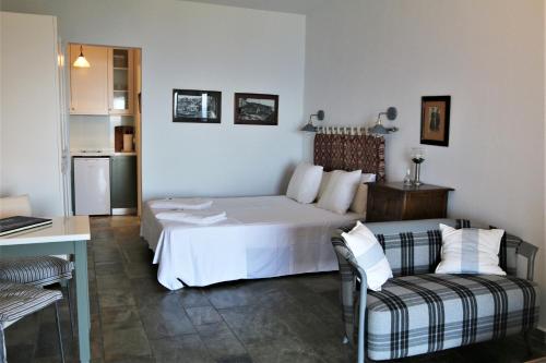 una camera con un letto bianco e un divano di Sea view studio a Mpatsi (Batsi)