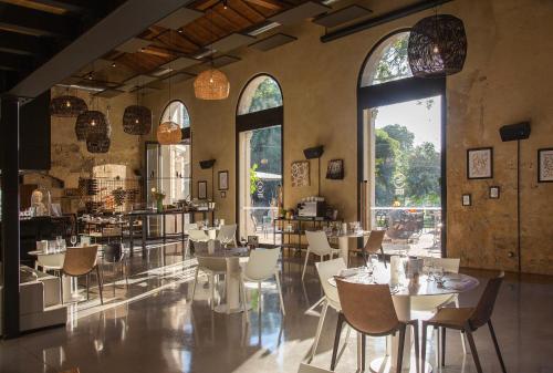 un restaurante con mesas, sillas y ventanas grandes en Domaine de Biar, en Montpellier