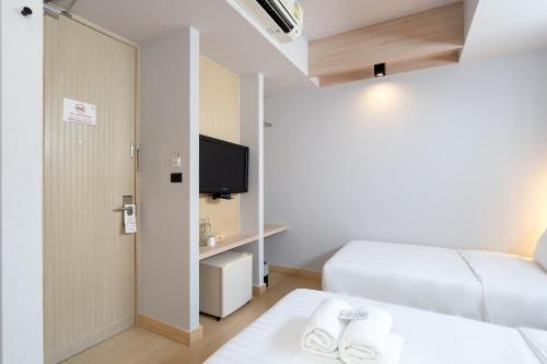 a small room with a bed and a tv at Metz Pratunam in Bangkok