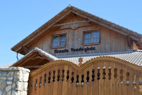a wooden building with a sign on top of it at Tiszafa Vendégház Szentgál in Szentgál