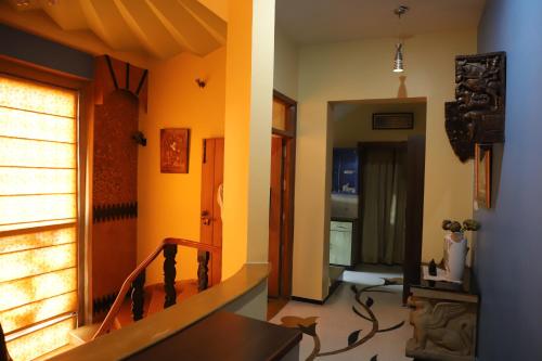 a room with a staircase and a hallway with yellow walls at Aura Homestay Royal Villa in Jaipur