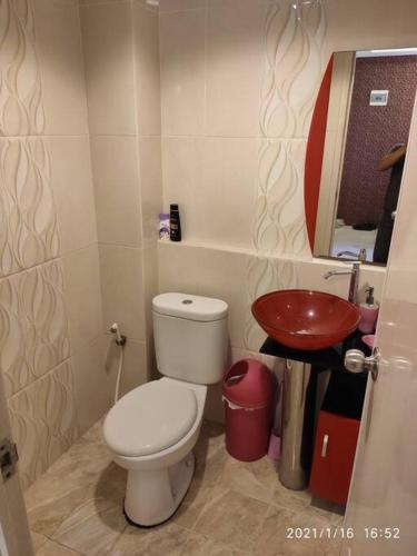 a small bathroom with a toilet and a sink at Pakubuwono Terrace Apt,good location in Jakarta