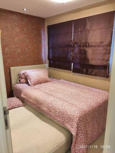 a bedroom with two beds with pink sheets at Pakubuwono Terrace Apt,good location in Jakarta