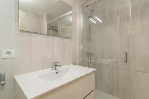 uma casa de banho branca com um lavatório e um chuveiro em Edisol 29 -Villa Pilar 2- em Port d'Addaia