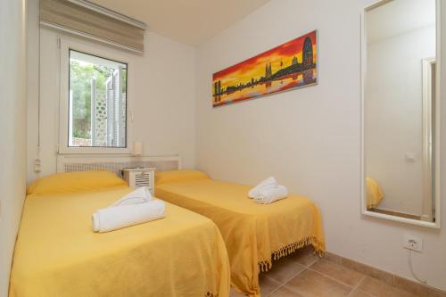 two beds in a room with yellow sheets at Edisol 29 -Villa Pilar 2- in Port d'Addaia