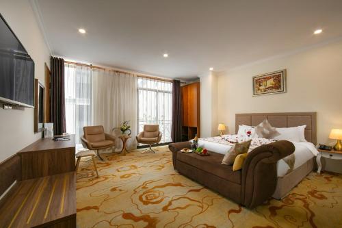 Habitación de hotel con cama y sala de estar. en Nesta Hotel Saigon, en Ho Chi Minh