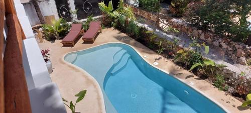 an overhead view of a swimming pool with two lounge chairs at Namayani apartment in Pwani Mchangani